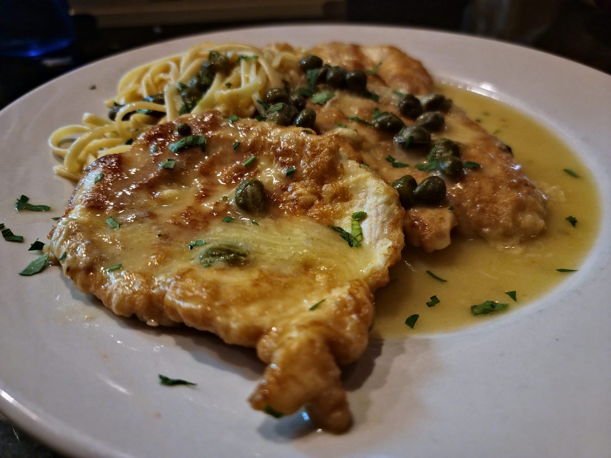 Chicken piccata with capers over linguine